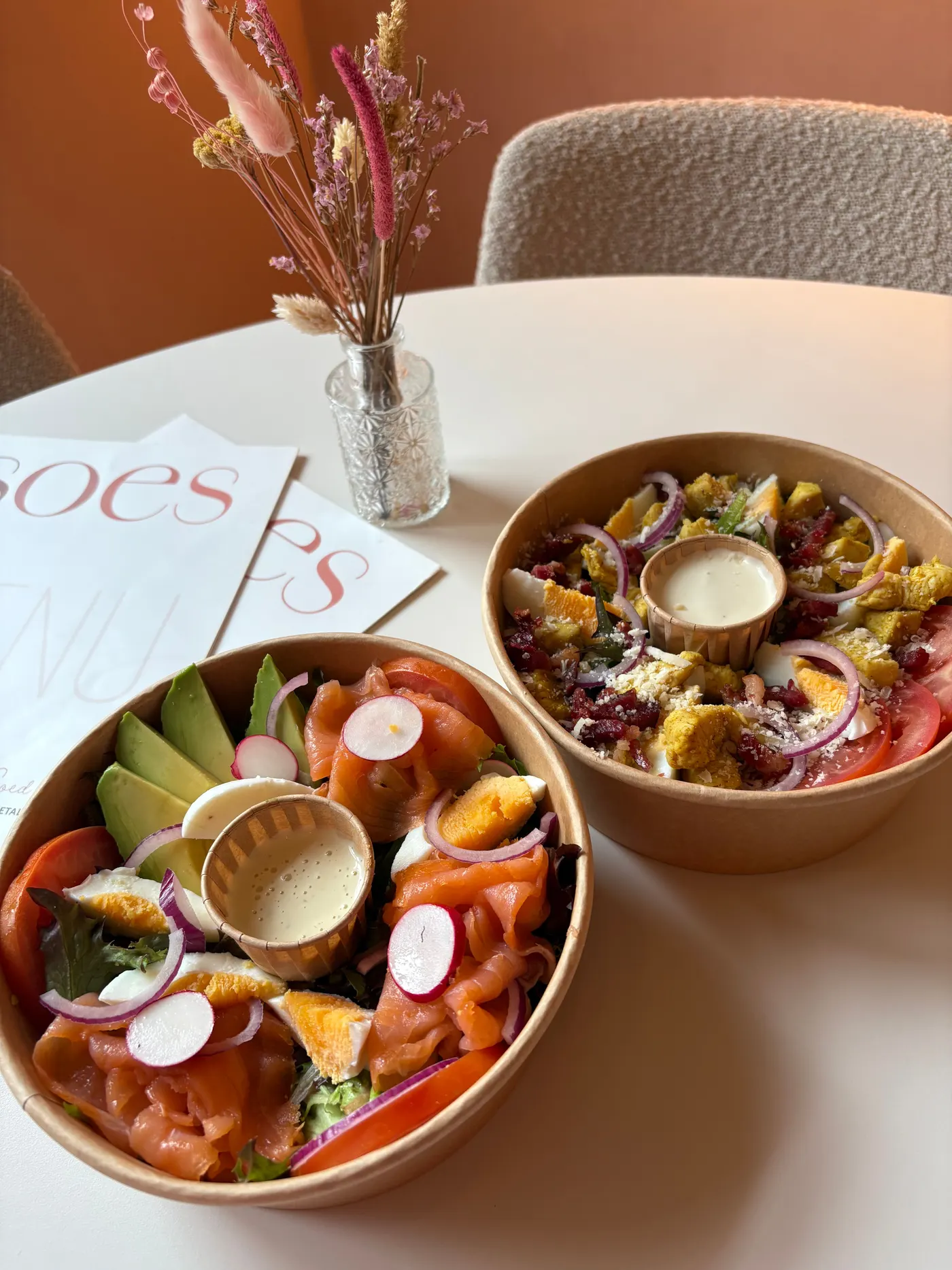 Twee verse salades met zalm en ei op tafel